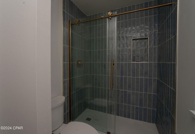 bathroom with toilet and a shower with shower door