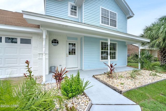 property entrance with a garage and covered porch