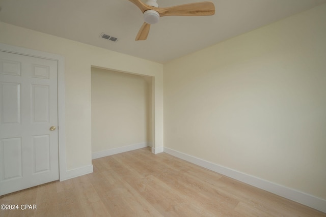 unfurnished bedroom featuring ceiling fan, light hardwood / wood-style flooring, and a closet