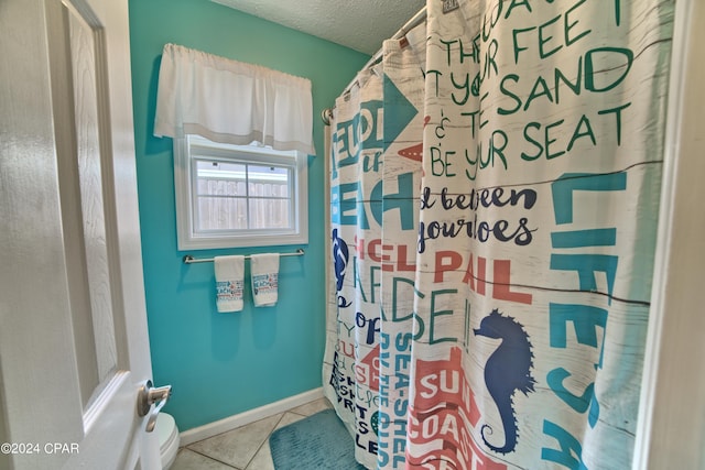 bathroom with tile patterned floors, curtained shower, and a textured ceiling