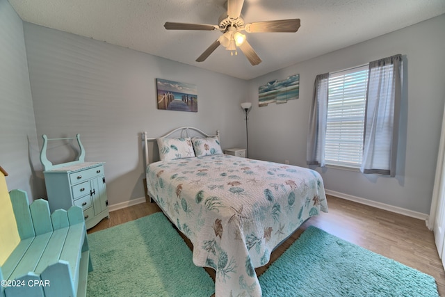 bedroom featuring ceiling fan, a textured ceiling, and hardwood / wood-style floors