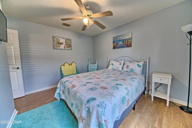 bedroom featuring ceiling fan, a textured ceiling, and light hardwood / wood-style flooring