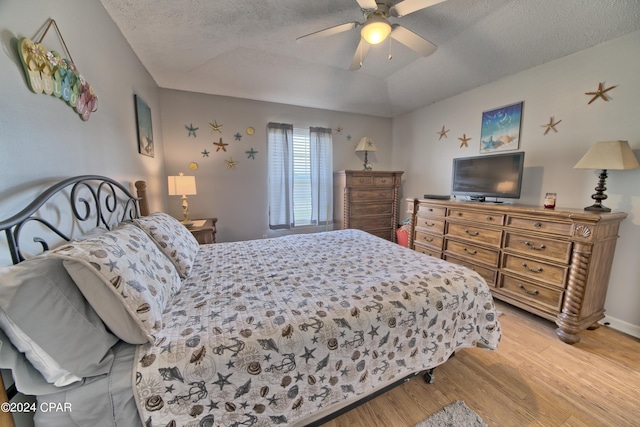 bedroom with light hardwood / wood-style floors, a textured ceiling, and ceiling fan