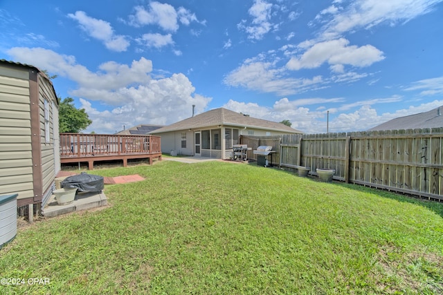 view of yard featuring a wooden deck and a patio