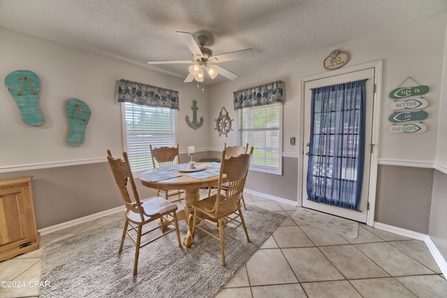 dining area with a textured ceiling, ceiling fan, light tile patterned floors, and a wealth of natural light