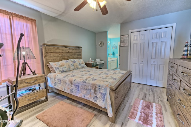 bedroom featuring a closet, a textured ceiling, light hardwood / wood-style floors, and ceiling fan