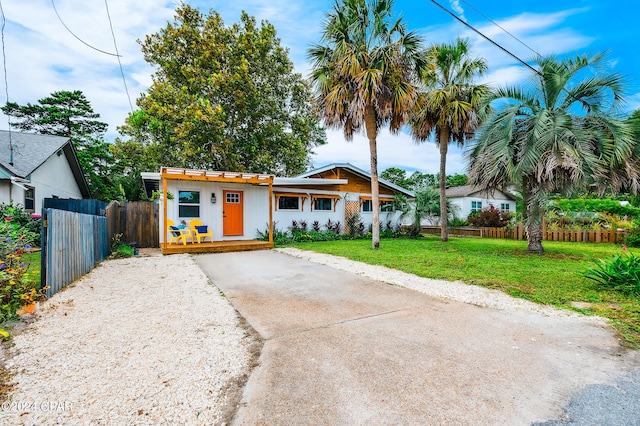 view of front of home featuring concrete driveway, a front yard, and fence