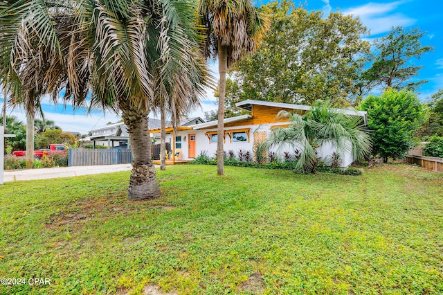 view of front of property featuring concrete driveway, a front yard, and fence