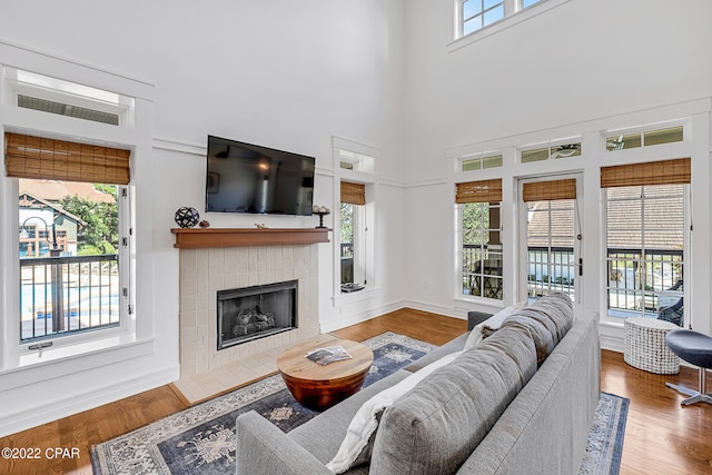 living room with wood-type flooring and a tile fireplace