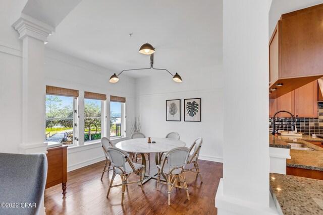 dining room featuring dark hardwood / wood-style flooring, ornate columns, and sink