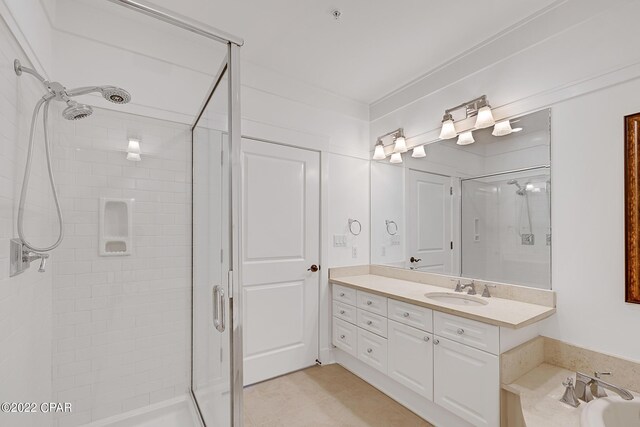 bathroom with tile patterned floors, a shower with door, and vanity