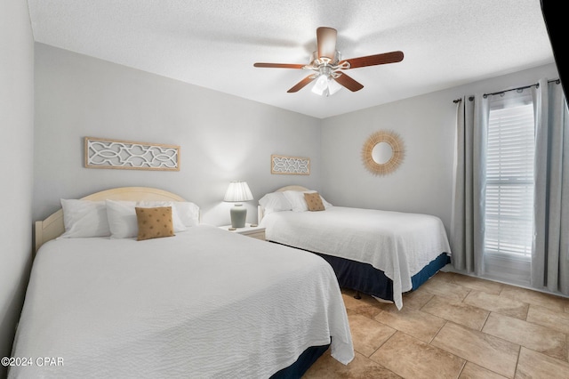 bedroom featuring ceiling fan and a textured ceiling