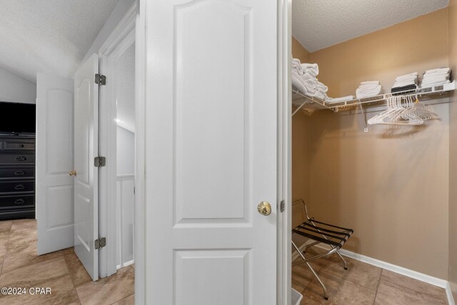 spacious closet with light tile patterned floors