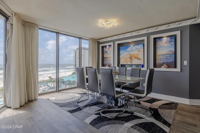 dining area with a water view, wood-type flooring, and a wealth of natural light