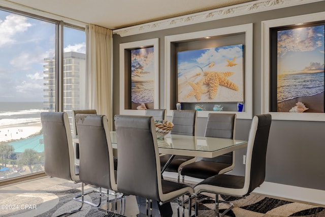 dining space featuring expansive windows, a water view, and wood finished floors