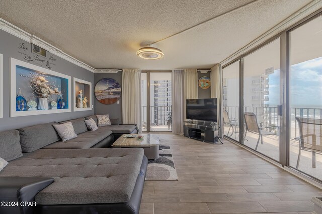 living room with a textured ceiling, expansive windows, and hardwood / wood-style flooring