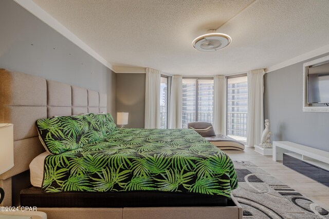 bedroom with light hardwood / wood-style floors and a textured ceiling