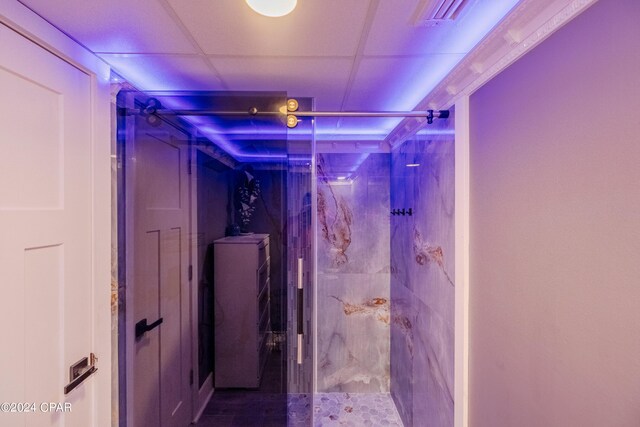 bathroom with a paneled ceiling and walk in shower