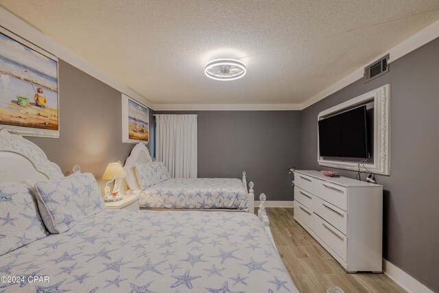 bedroom featuring a textured ceiling and light hardwood / wood-style floors