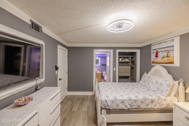 bedroom with a textured ceiling and light hardwood / wood-style floors