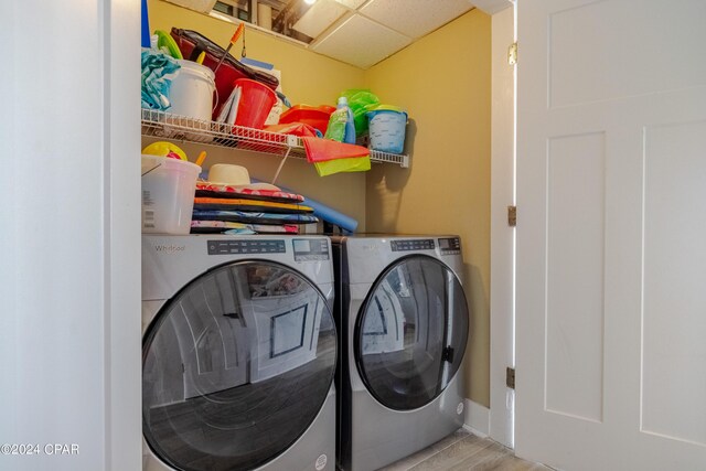 clothes washing area featuring light hardwood / wood-style floors and washing machine and dryer