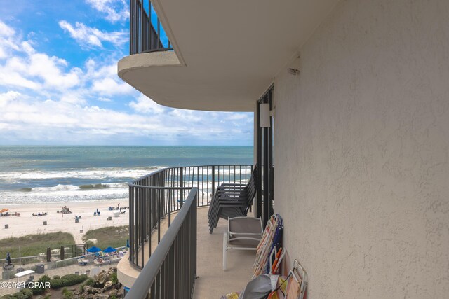 balcony featuring a beach view and a water view