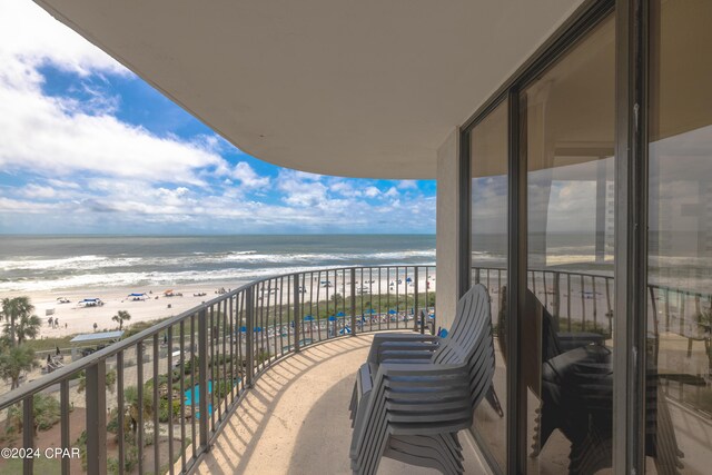 balcony featuring a beach view and a water view