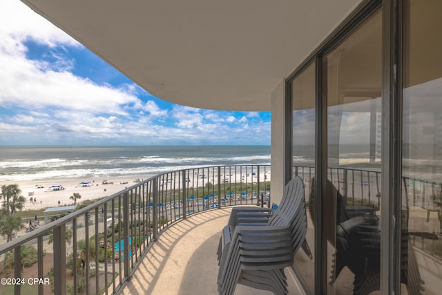 balcony featuring a water view and a beach view