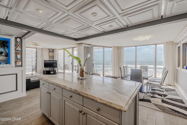 kitchen featuring a kitchen island, light hardwood / wood-style flooring, and light stone countertops