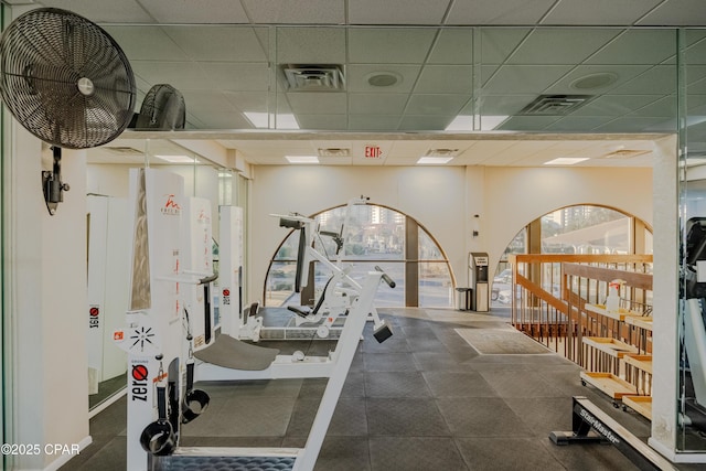 gym with a paneled ceiling and visible vents