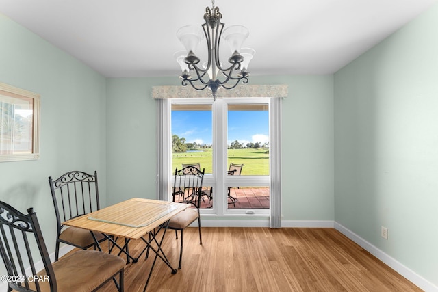 dining area with a notable chandelier, light wood-type flooring, and a healthy amount of sunlight