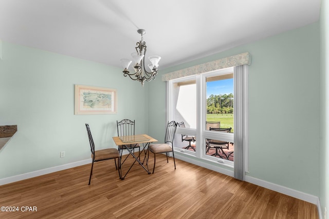 dining space with a notable chandelier and light hardwood / wood-style floors