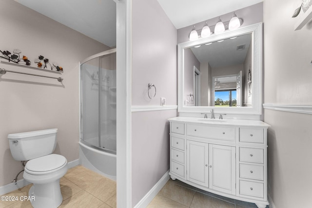 full bathroom featuring bath / shower combo with glass door, vanity, tile patterned flooring, and toilet