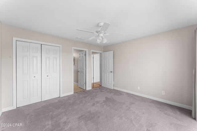 unfurnished bedroom with ceiling fan, a closet, and light carpet