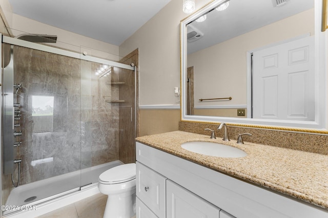 bathroom featuring tile patterned floors, a shower with door, vanity, and toilet