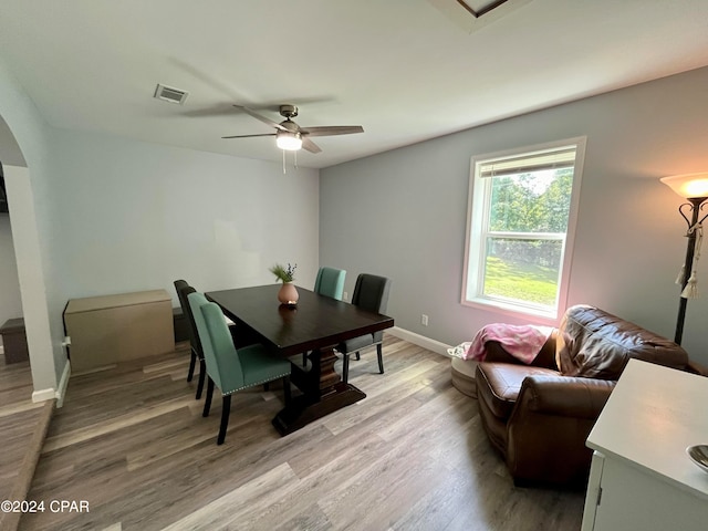 dining space with ceiling fan and light wood-type flooring