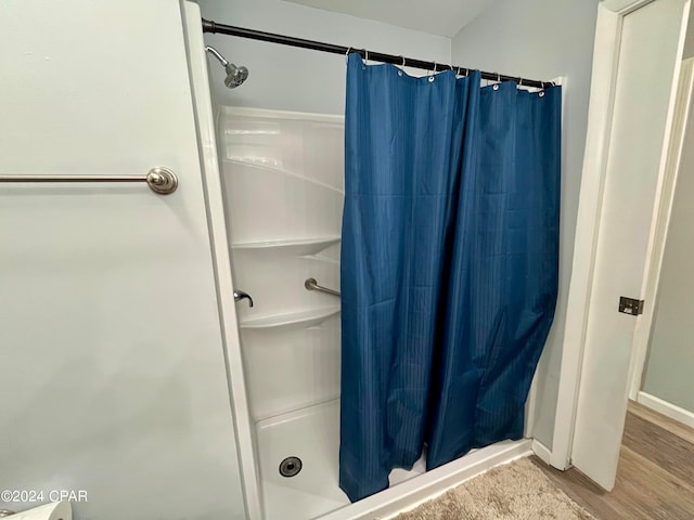 bathroom with hardwood / wood-style floors and curtained shower