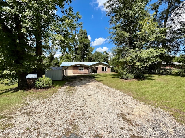 view of front of property featuring a front yard and a shed