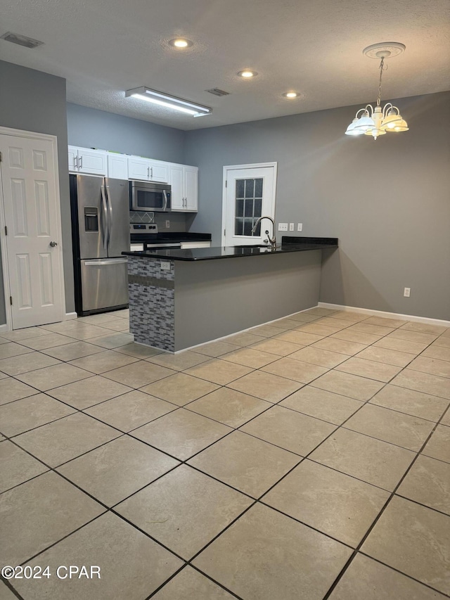 kitchen with pendant lighting, kitchen peninsula, a chandelier, white cabinetry, and stainless steel appliances