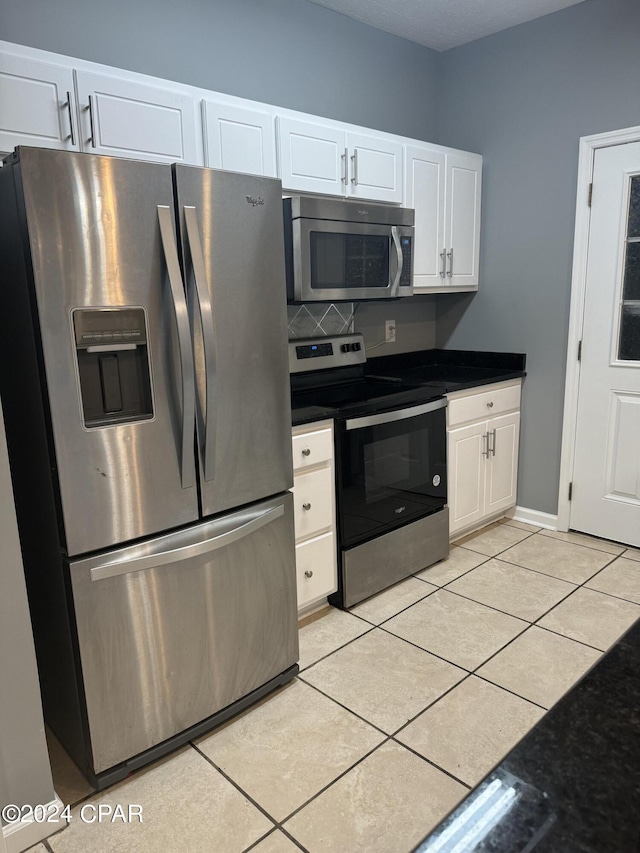 kitchen featuring stainless steel appliances, white cabinetry, and light tile patterned floors