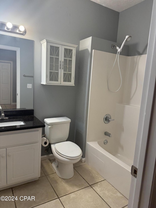 full bathroom with vanity, tile patterned flooring, a textured ceiling, bathing tub / shower combination, and toilet