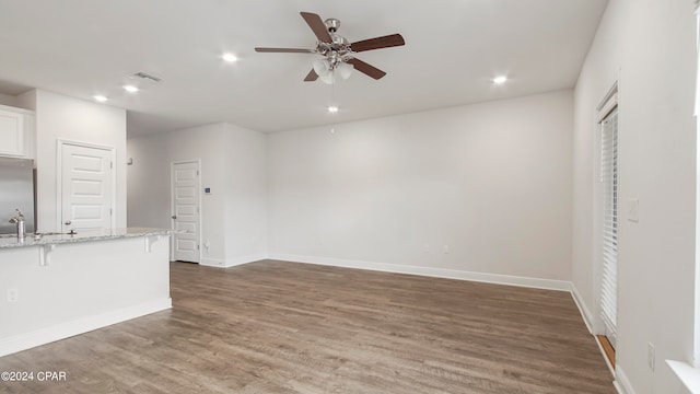 unfurnished living room featuring ceiling fan, dark hardwood / wood-style floors, and sink