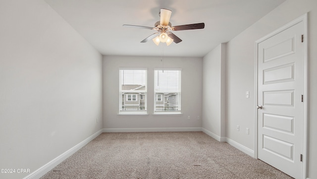 carpeted spare room featuring ceiling fan