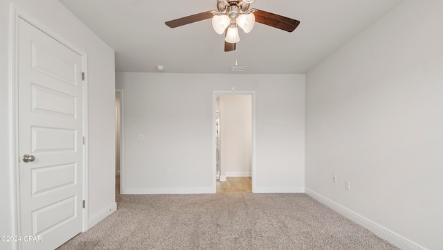 empty room featuring ceiling fan and light carpet