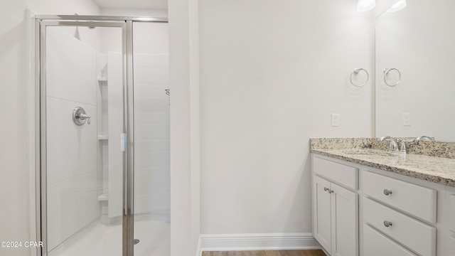 bathroom featuring wood-type flooring, vanity, and a shower with door