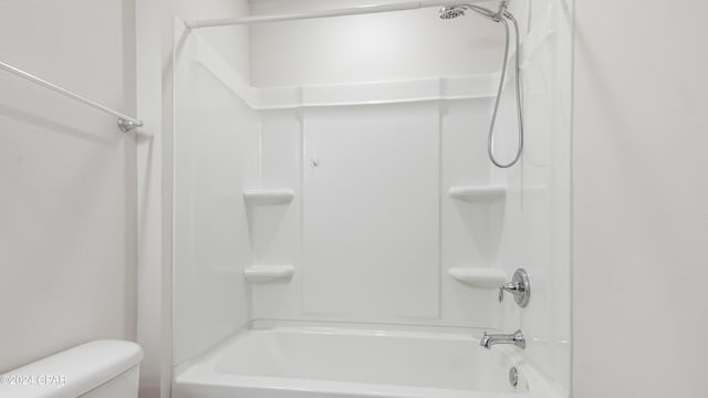 bathroom featuring shower / washtub combination and toilet