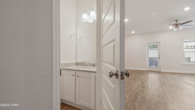 bathroom with ceiling fan, vanity, and wood-type flooring