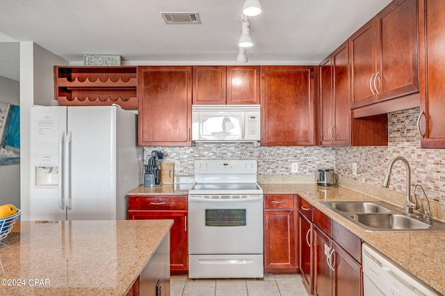 kitchen featuring white appliances, sink, light stone counters, and light tile patterned floors