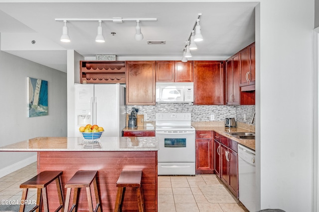 kitchen featuring a kitchen breakfast bar, white appliances, sink, and pendant lighting