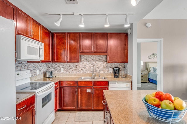 kitchen with tasteful backsplash, sink, white appliances, and light tile patterned floors